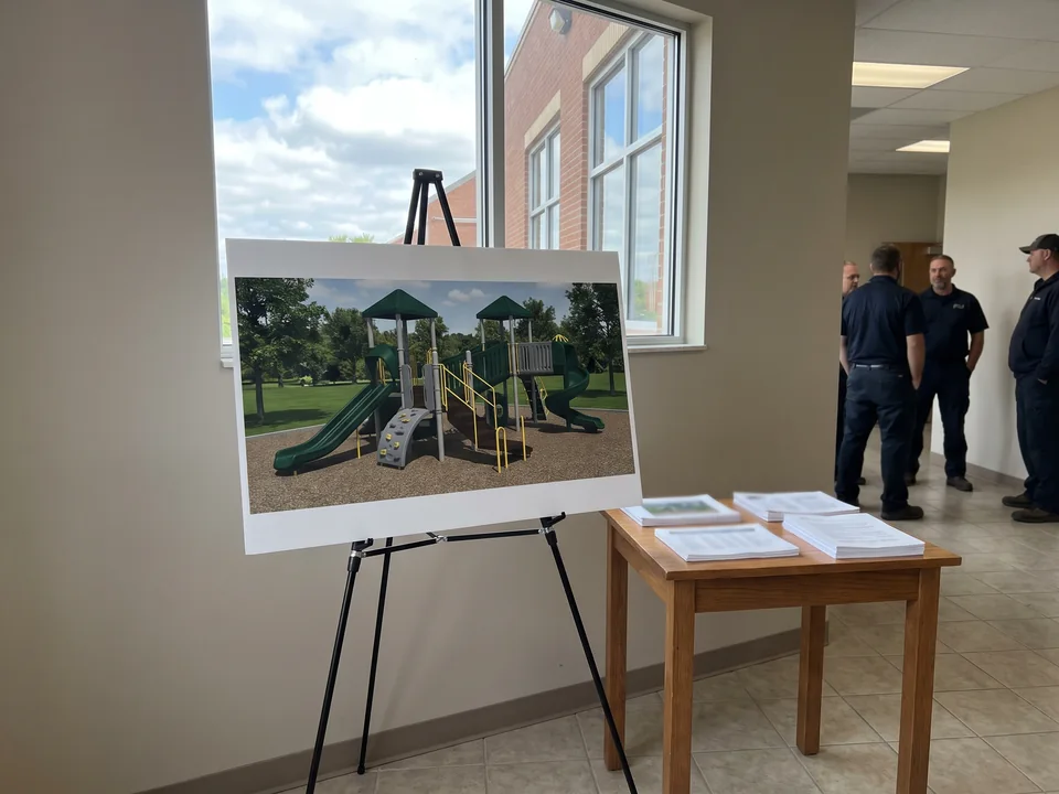Fundraising board with a playground render on an easel in a church foyer