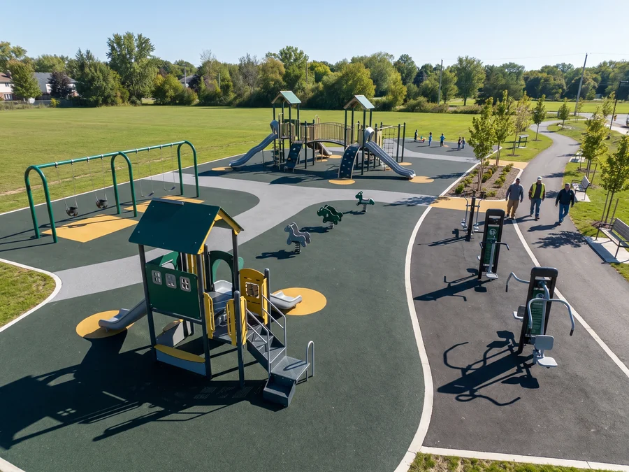Municipal park playground with two structures, a swing bay and fitness stations