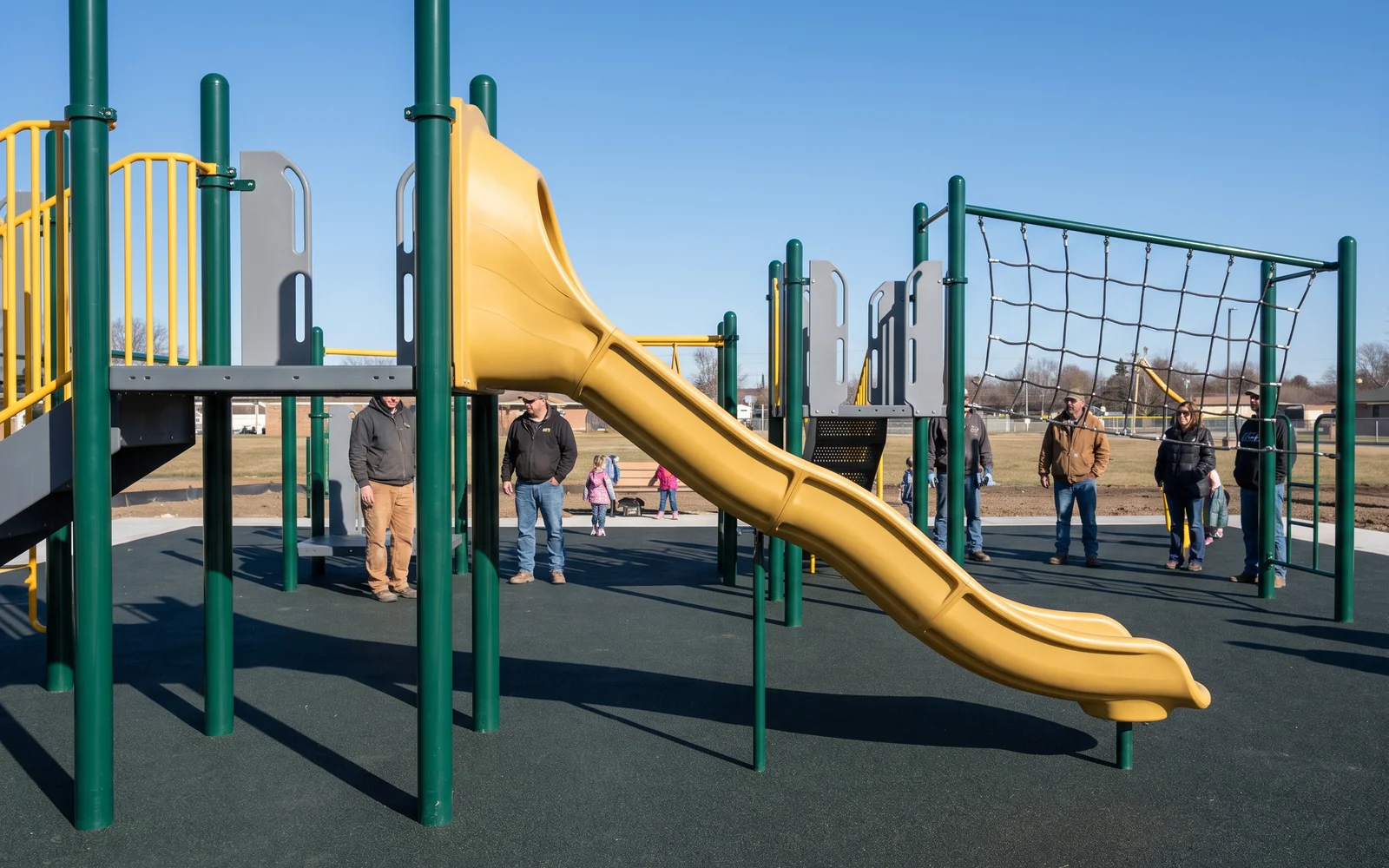 An installed play structure with steel posts, a rotomolded slide and a climbing net up to the deck