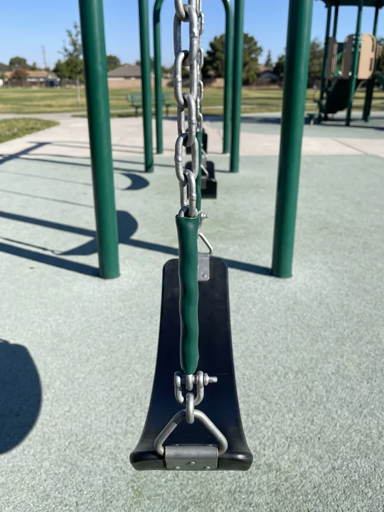 A black rubber belt swing seat hanging still on galvanized chains with plastisol grips