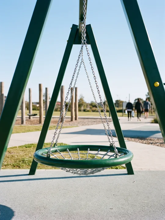 A nest swing with a rope net on a padded steel ring, hung from several points