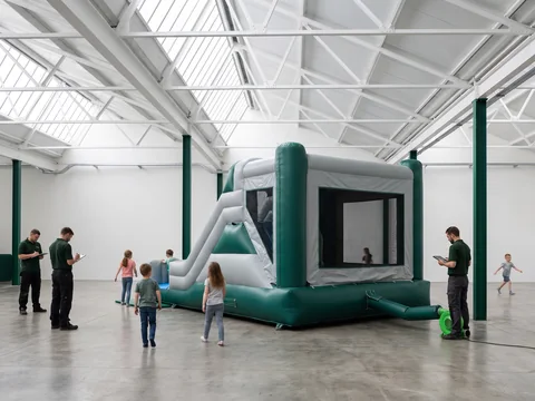 Indoor combo inflatable in evergreen and light grey with a slide and mesh walls