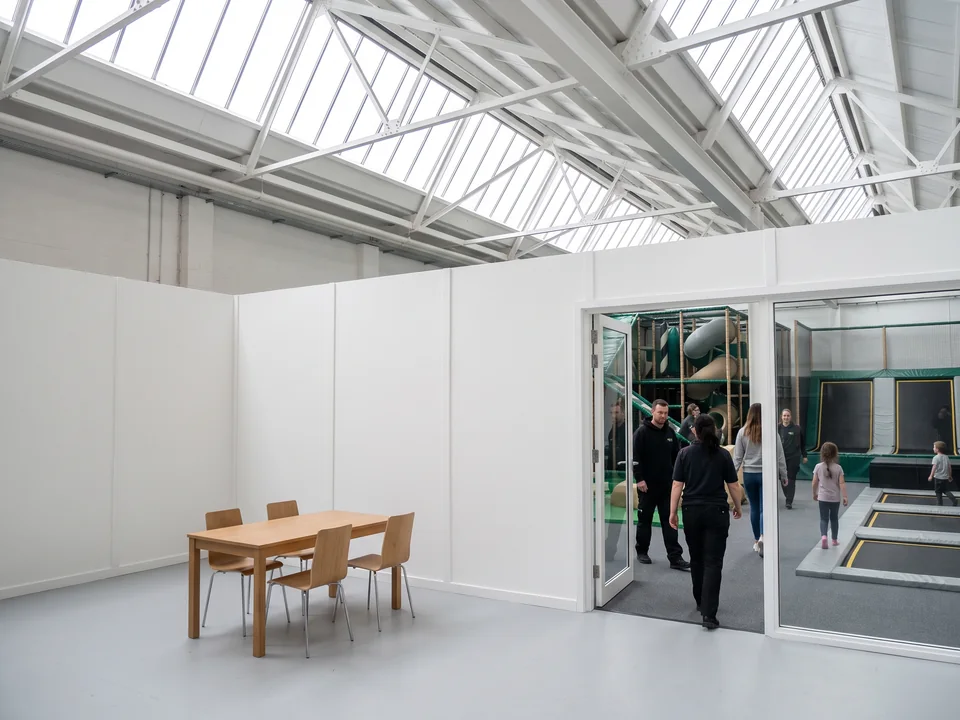 Empty party room with a long table, built by the venue contractor beside the play floor