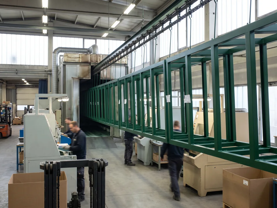 Row of evergreen powder-coated frames after coating
