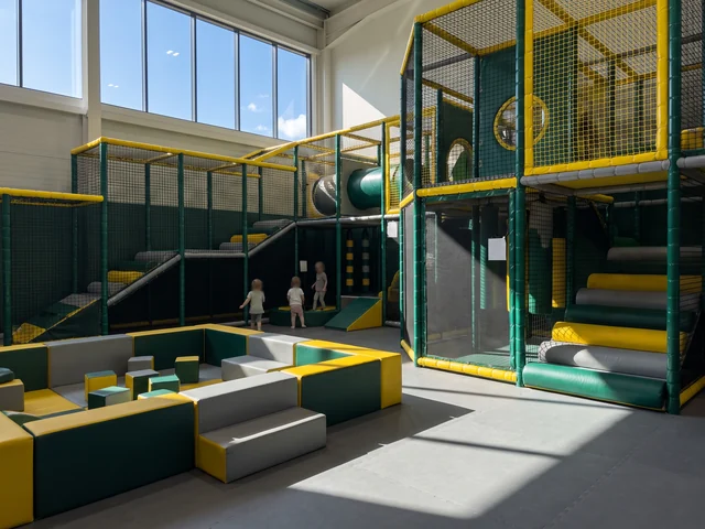 Multi-level soft play frame with padded platforms and netting