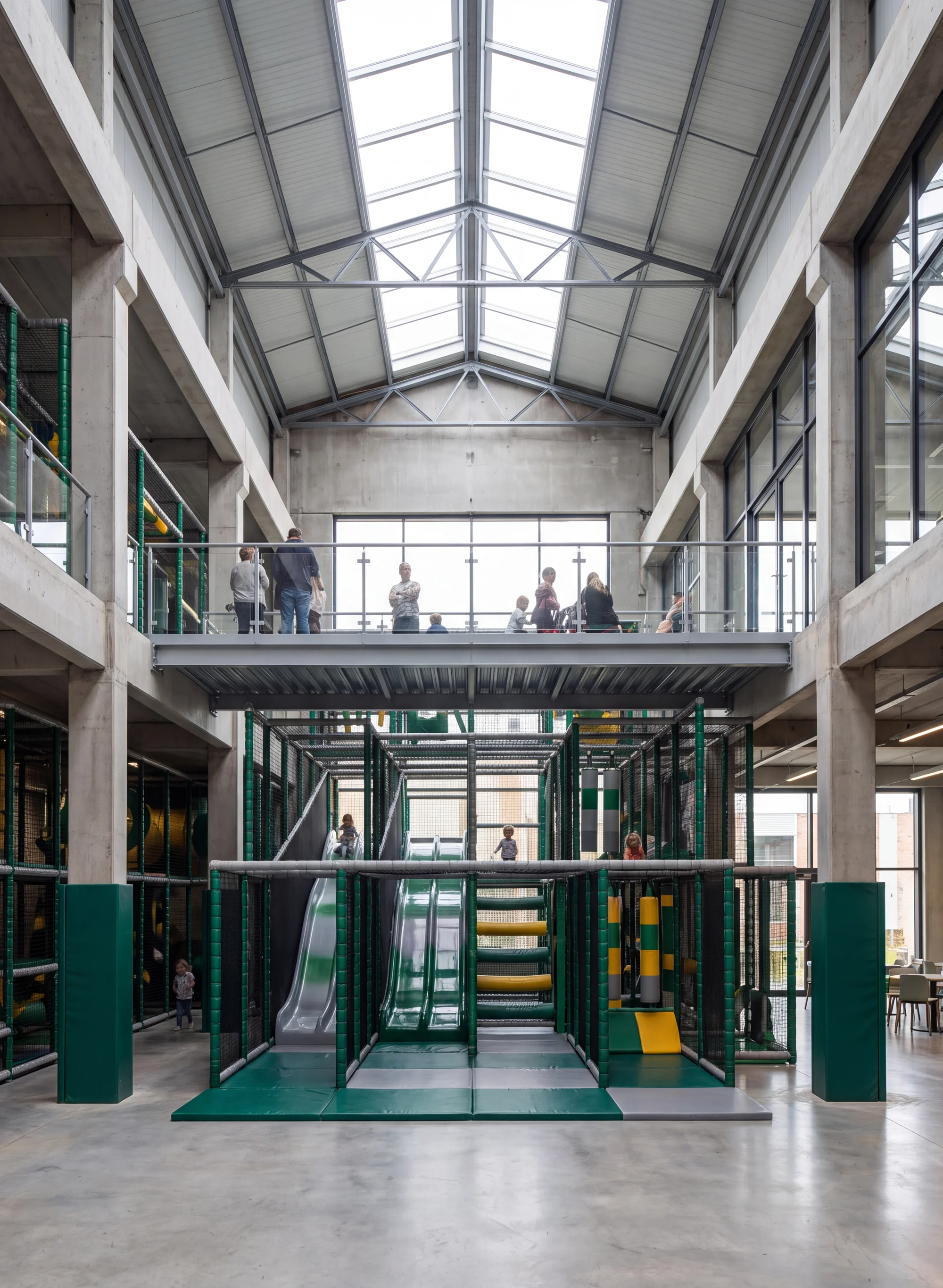 Multi-level soft play venue under a high ceiling with visible building columns