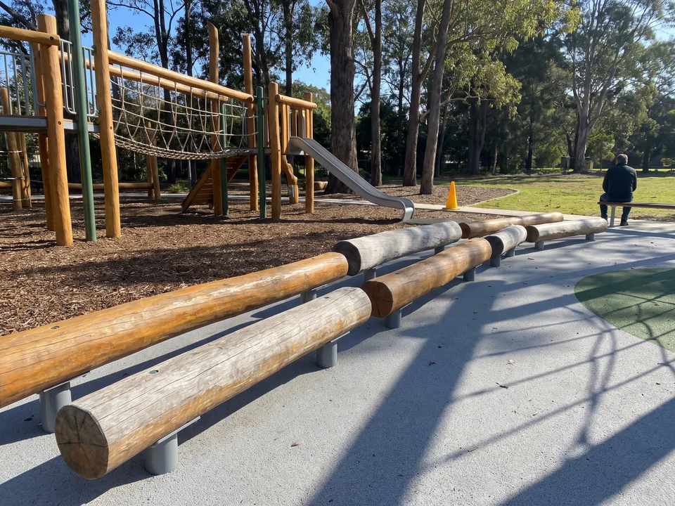 Robinia logs along the edge of a play area as seating