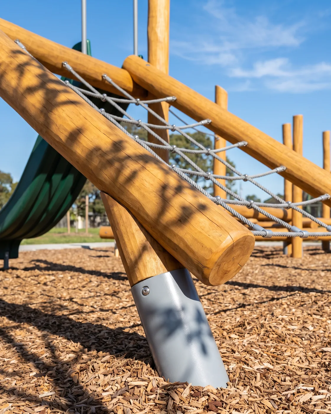 A corner of a Robinia climbing frame just installed, honey-colored timber