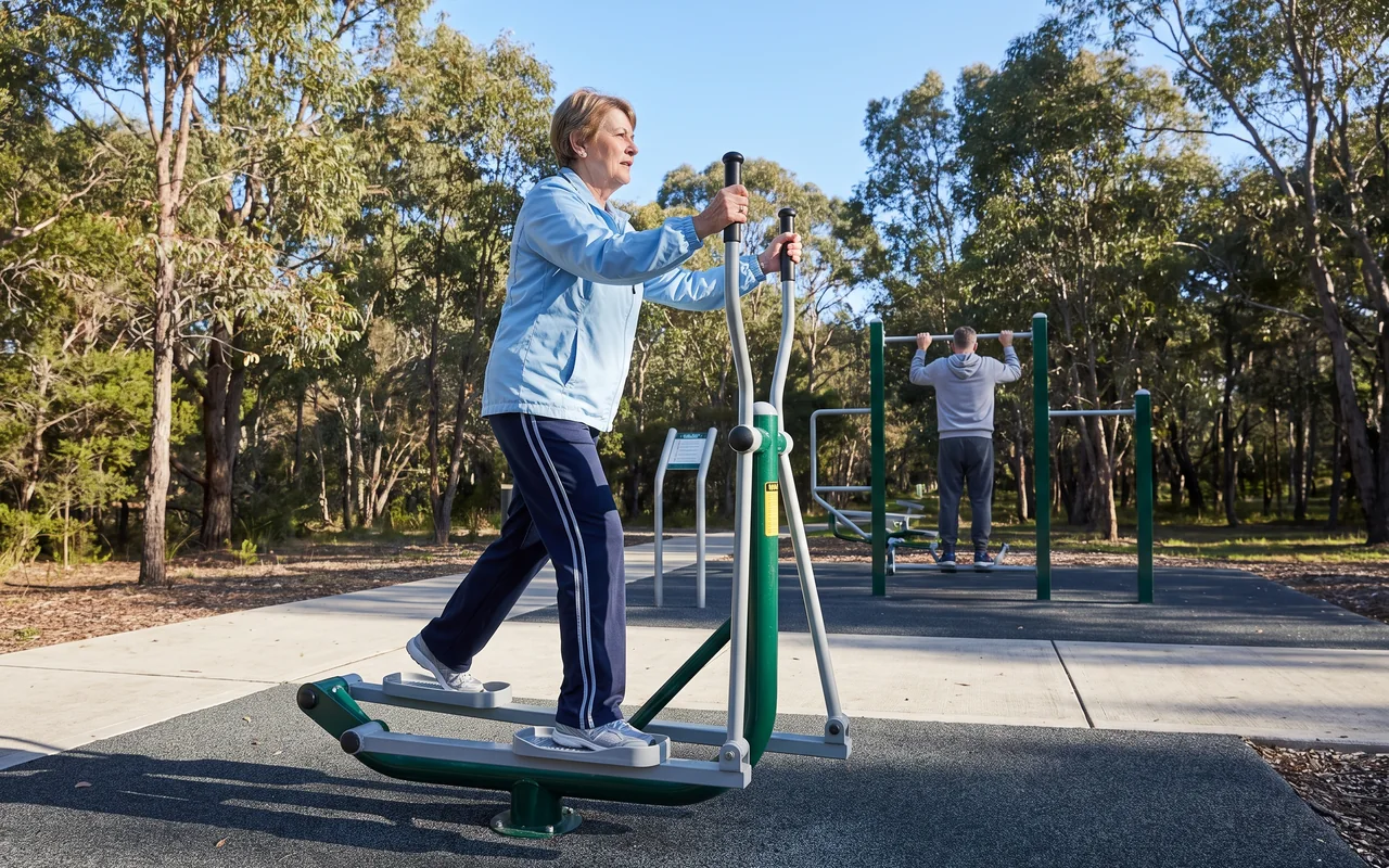 A woman in her sixties striding on an elliptical trainer in a park