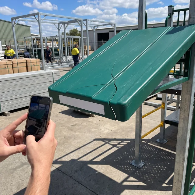 A hand photographing a cracked HDPE roof panel and its part label with a phone
