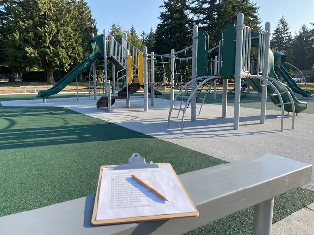 A printed standards checklist on a clipboard with a column of pencil ticks