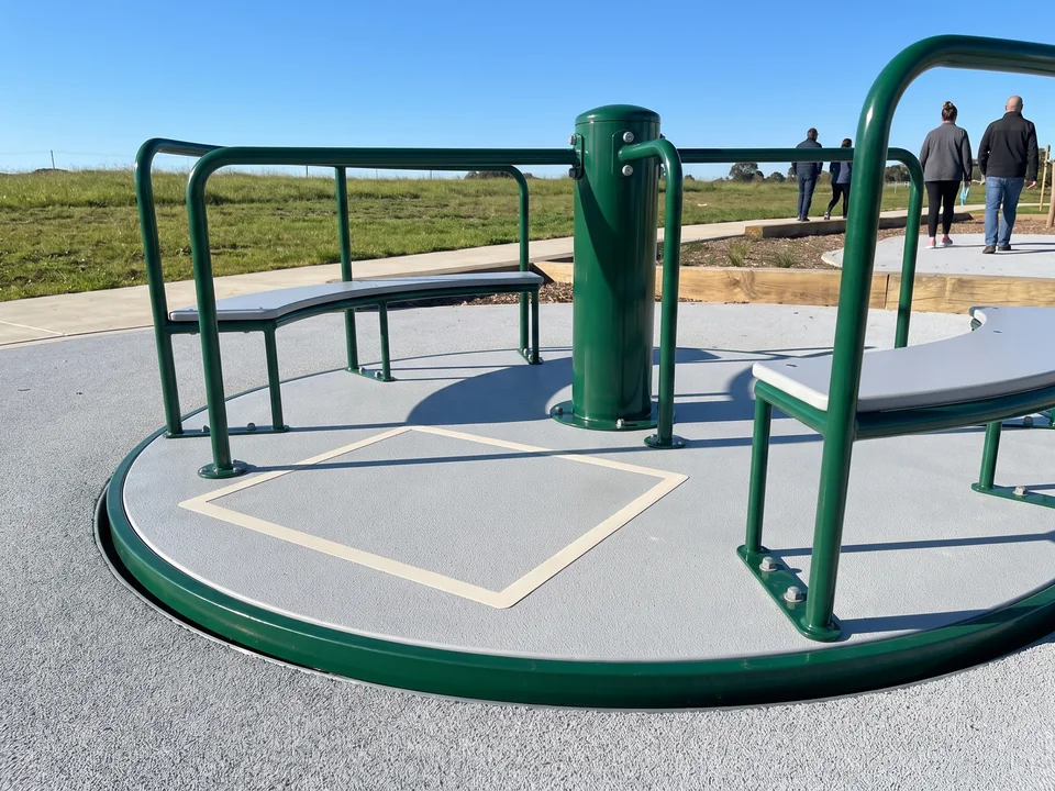 A ground-level inclusive spinner with a solid deck set level with the surrounding rubber surfacing