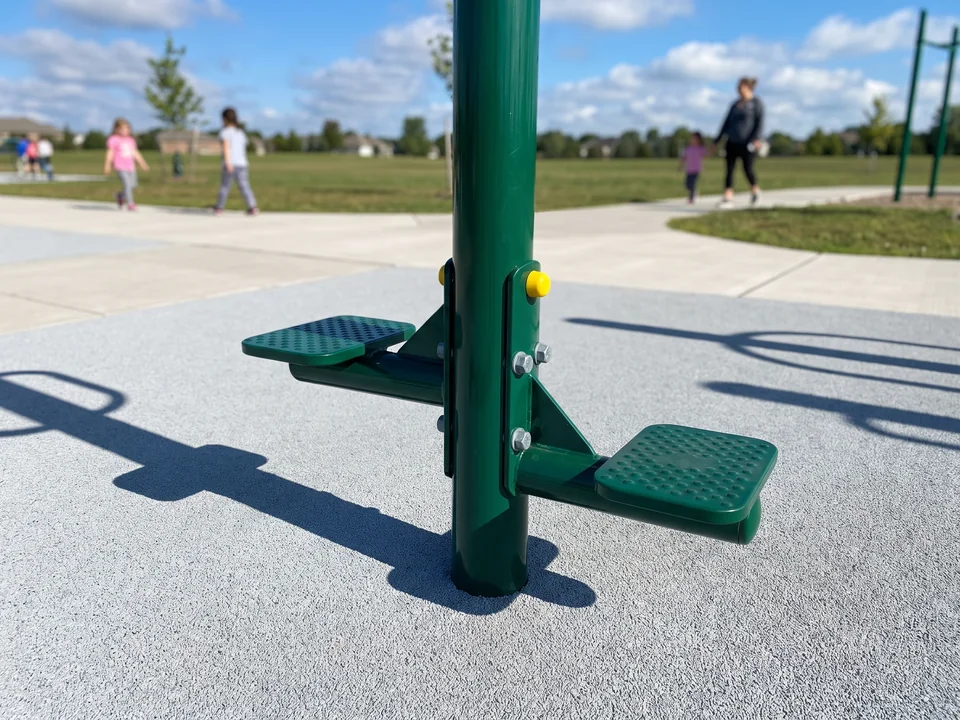 A standing spin pole with foot plates on rubber surfacing