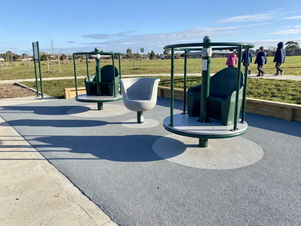 Two evergreen rotomolded spin seats and a spin cup side by side on rubber surfacing