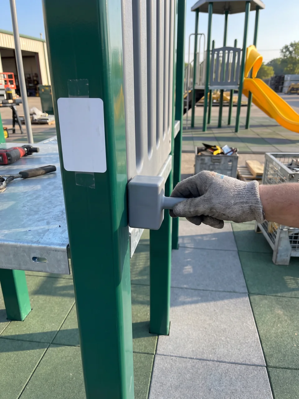 A QC inspector pushes a grey entrapment probe into the gap between a deck edge and a barrier panel on the pre-assembled structure