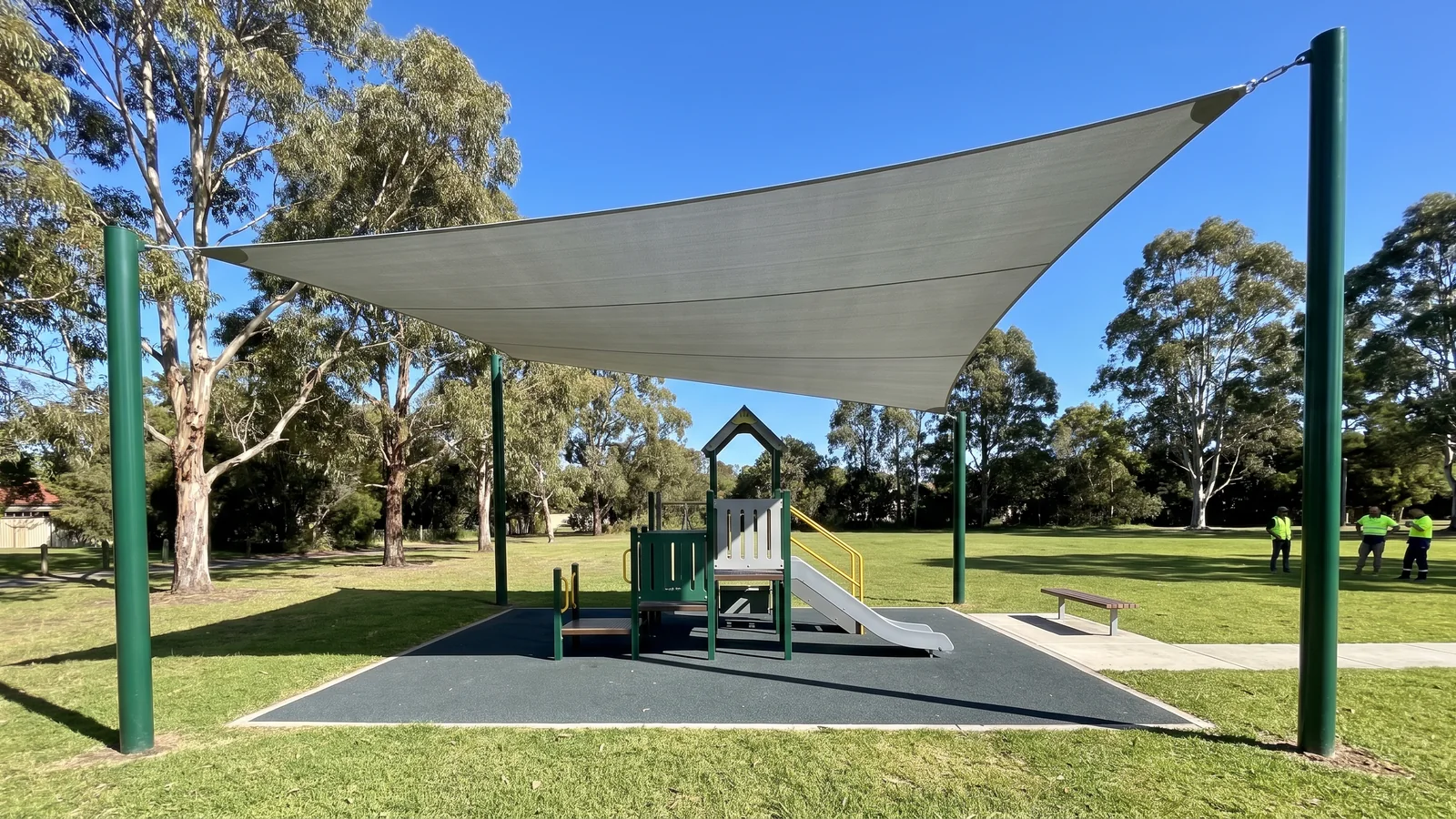 A large shade sail on its own four evergreen posts covering the whole play structure and the ground around it