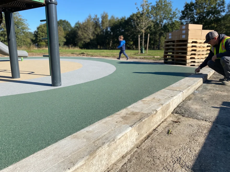 Poured-in-place zone finished at a concrete curb, flush with the adjoining path
