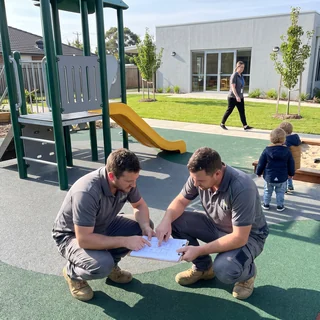 Installation crew reading drawings in a daycare yard