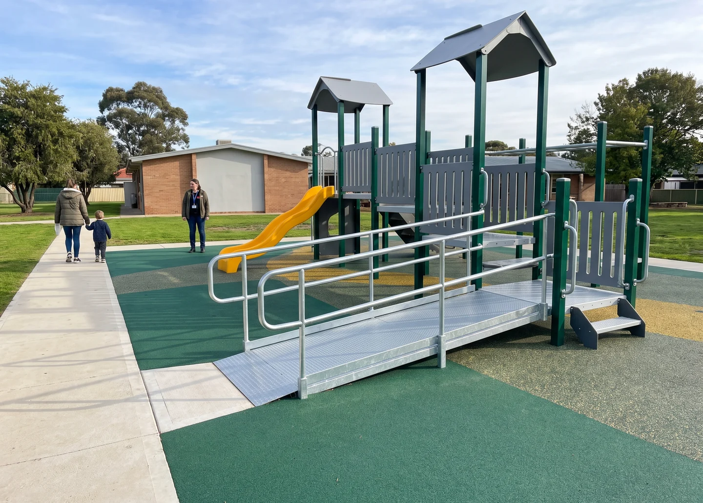 An accessible route running flush from a paved path onto rubber surfacing