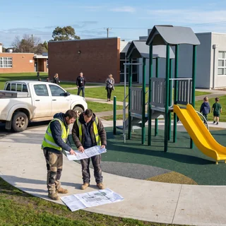 Installer crew reading a layout on a school site