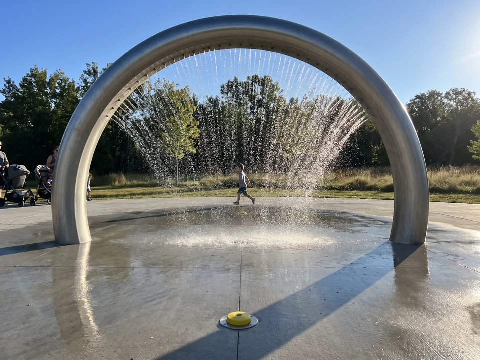 A stainless spray arch dropping a curtain of water from a line of nozzles