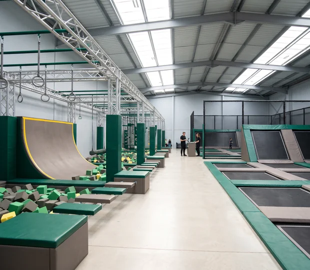 Ninja course obstacles on steel frames beside the trampoline courts