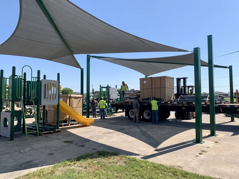 Shade sails on steel posts over a playground
